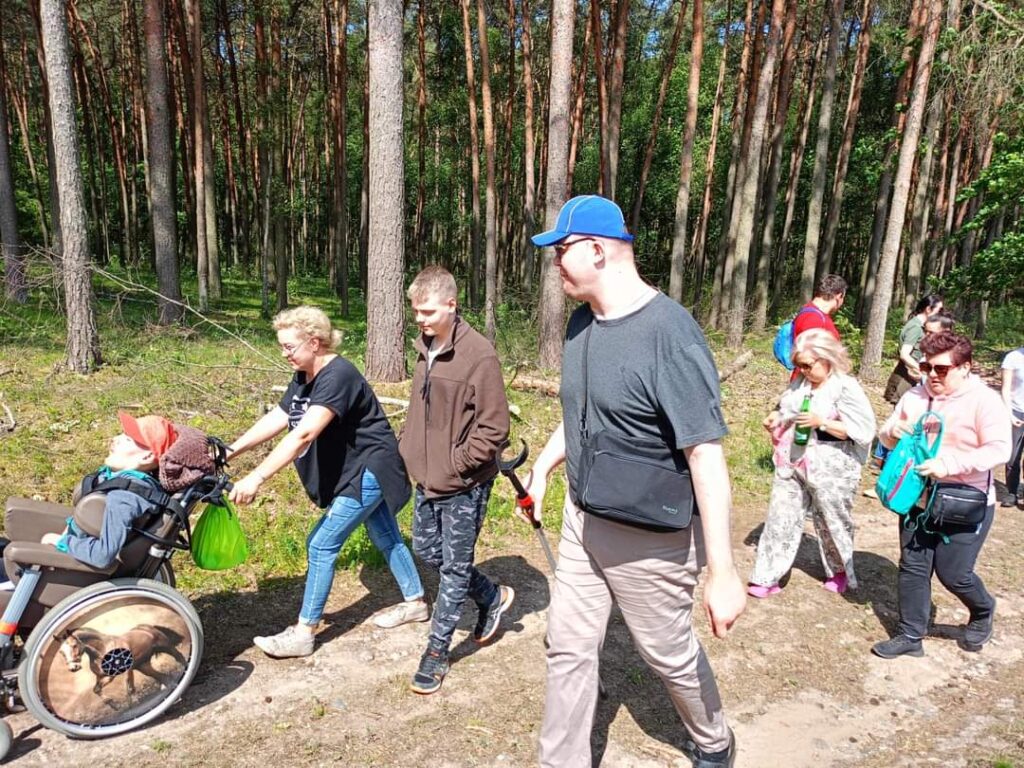 ludzie idący w lesie