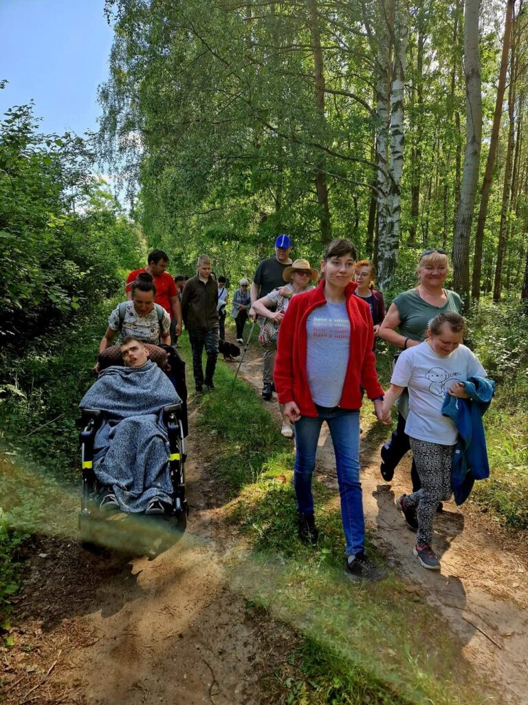 ludzie idący w lesie