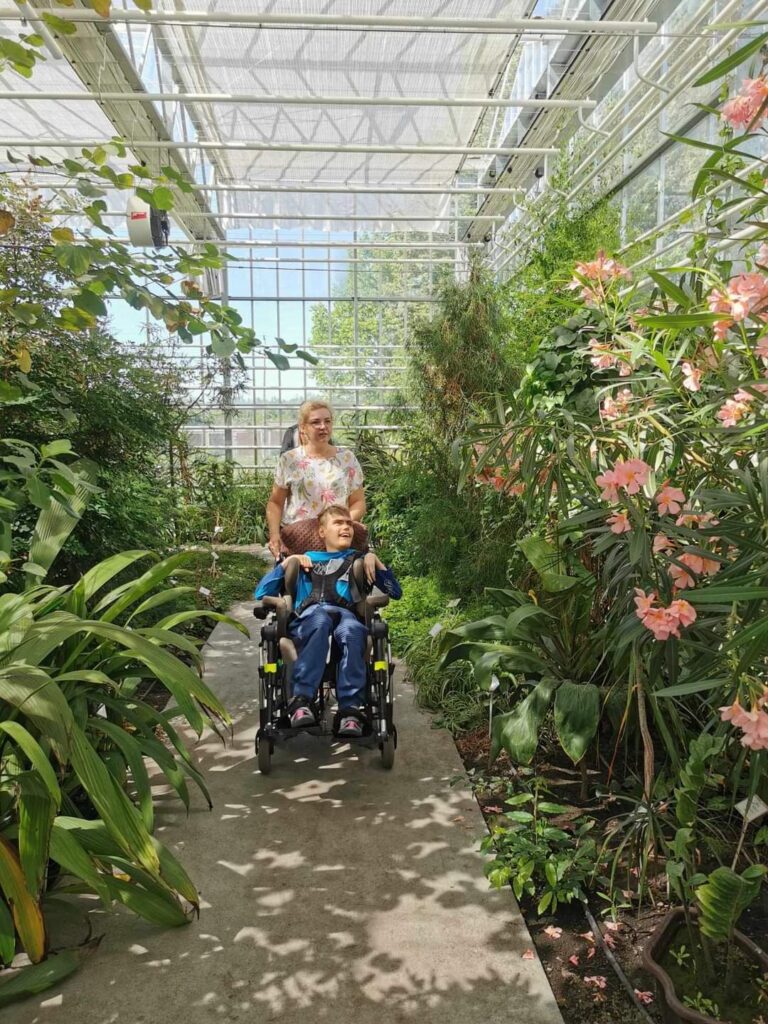 kobieta z z młodym mężczyznom na wózku inwalidzkim w szklarni