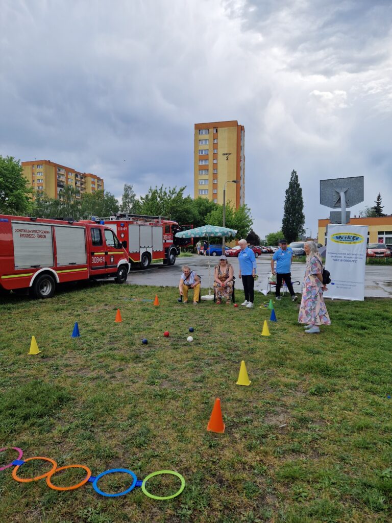 wozy strażackie i ludzie grający w boccię