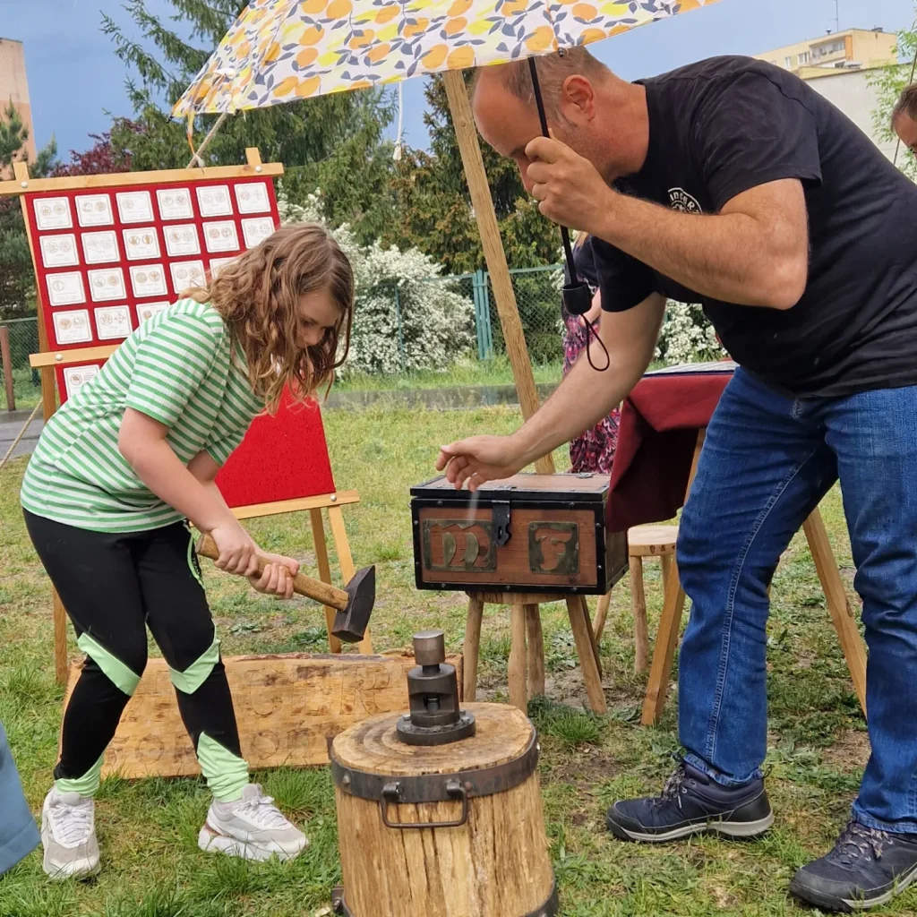 dziecko wybijające monetę i mincerz