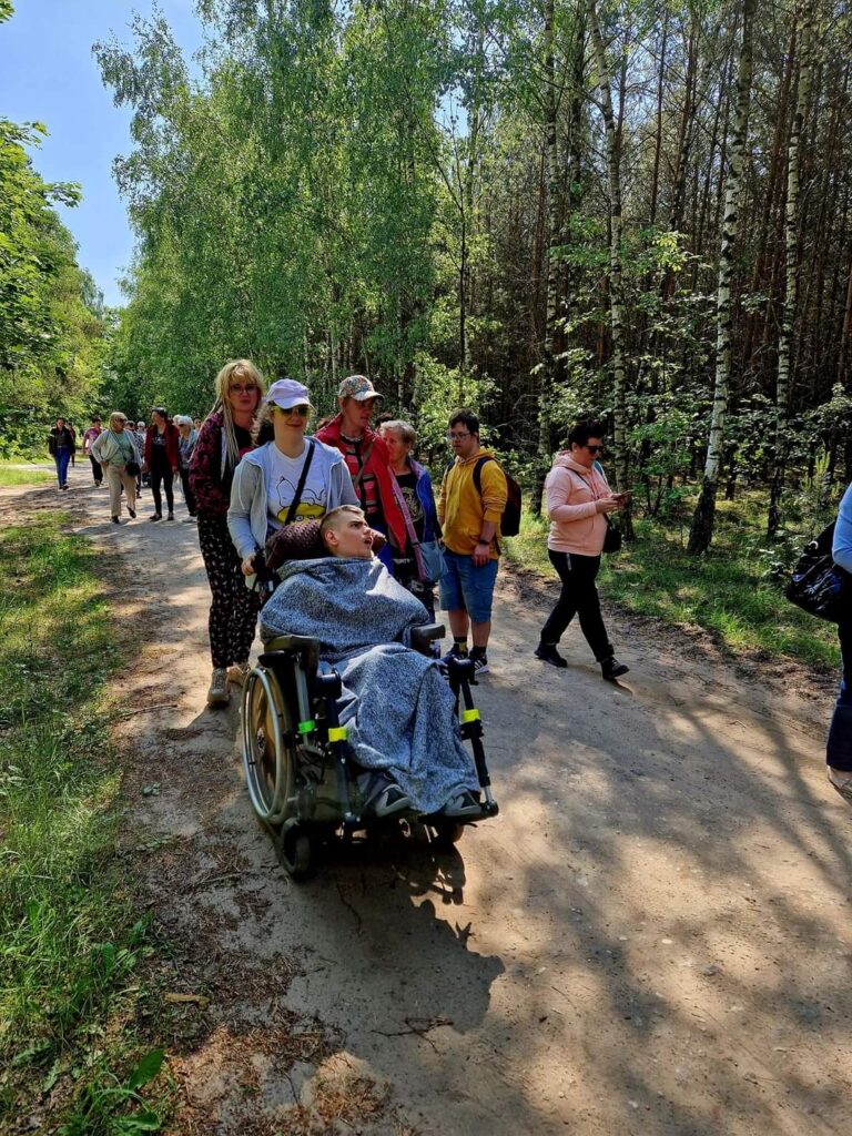 ludzie idący w lesie