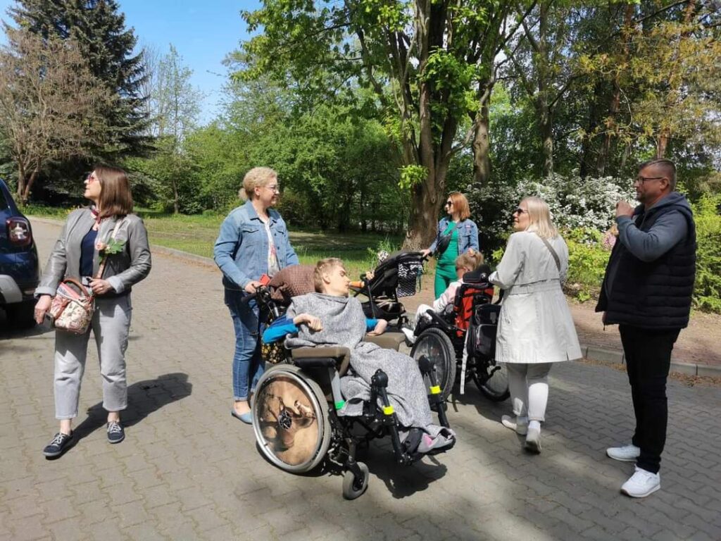 opiekunowie z podopiecznymi w ogrodzie