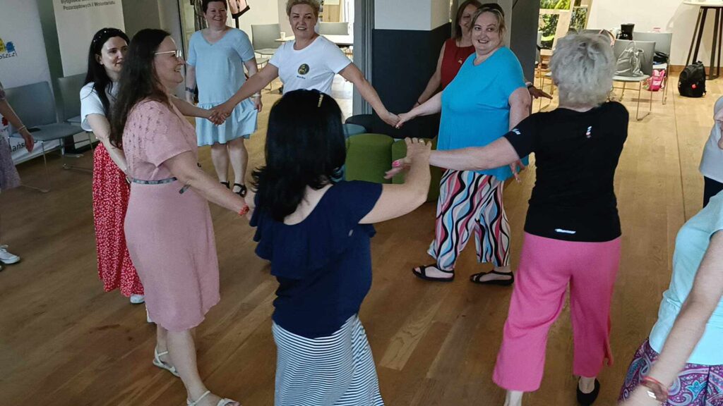 kobiety tańczące trzymają się za ręce