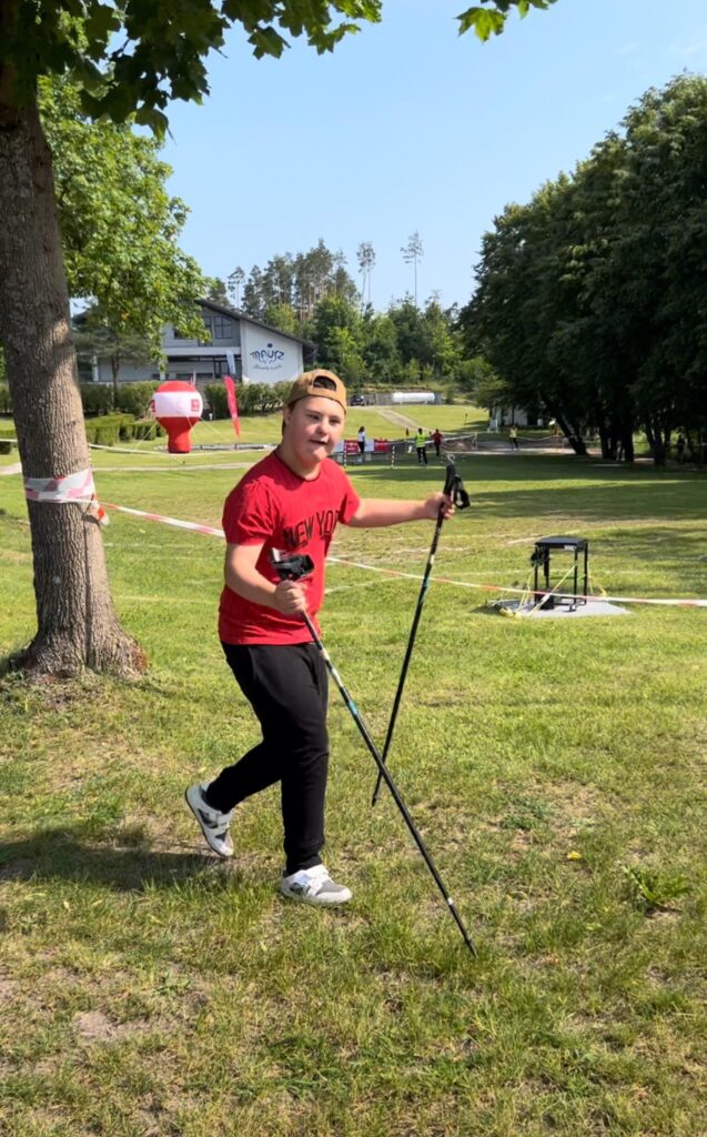 chłopiec z zespołem downa z kijami nordic walking