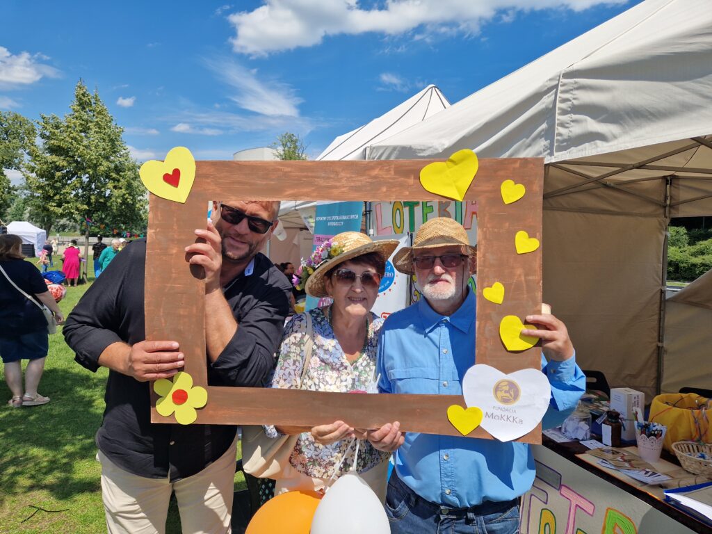 osoby pozujące do zdjęcia z ramką fundacji mokkka