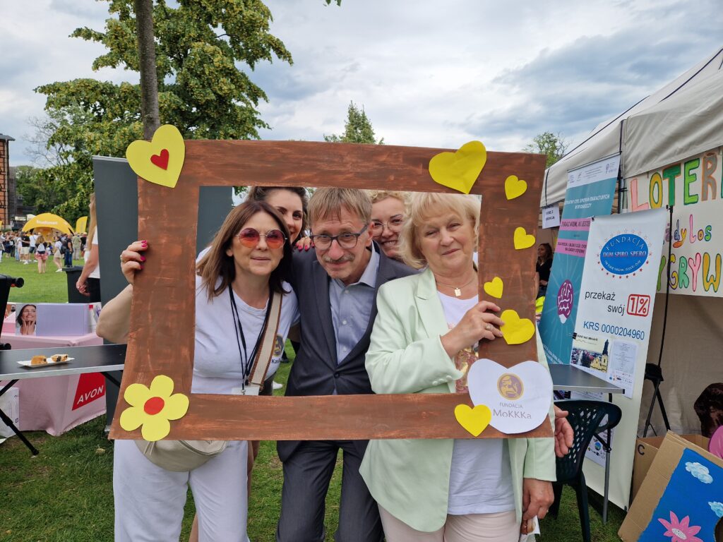 ludzie pozujący z ramką fundacji mokkka