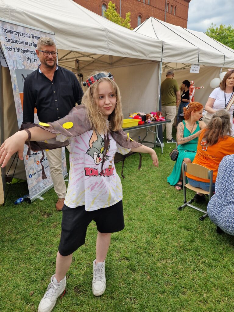 dziewczynka jako żuczek w tle namioty i ludzie