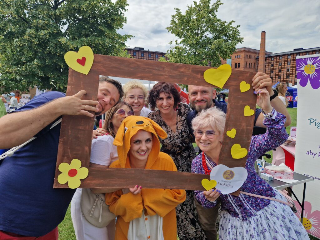 7 osób pozujących do zdjęcia z ramka fundacji mokkka