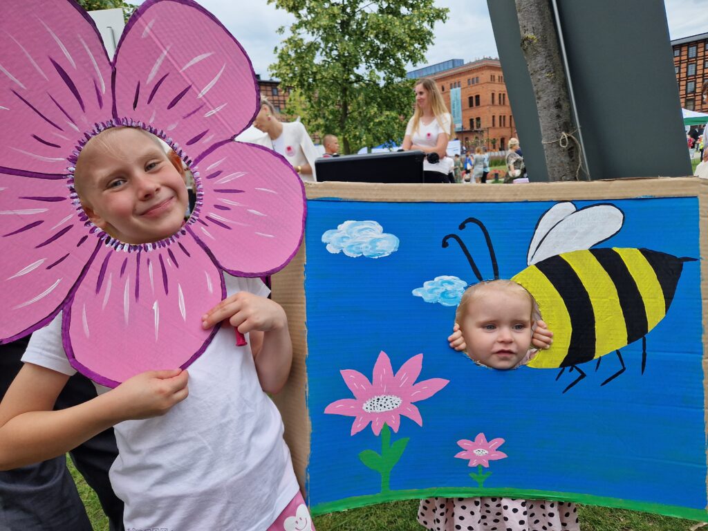 dwie dziewczynki pozują do zdjęcia jako kwiatek i pszczółka