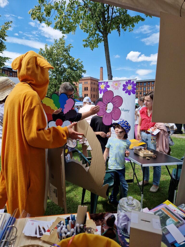 ludzie przy stoliku z grami wybierający akcesoria z fotobudki