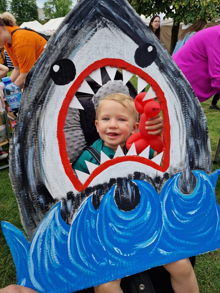 chłopczyk z balonem pozujący do zdjęcia jako rekin