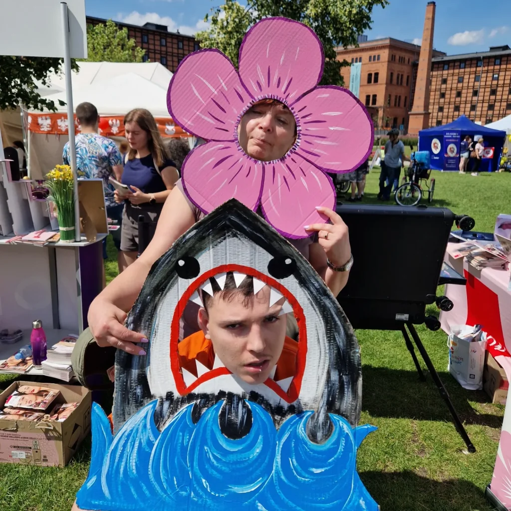 Kobieta pozująca do zdjęcia jako kwiatek i mężczyzna jako rekin