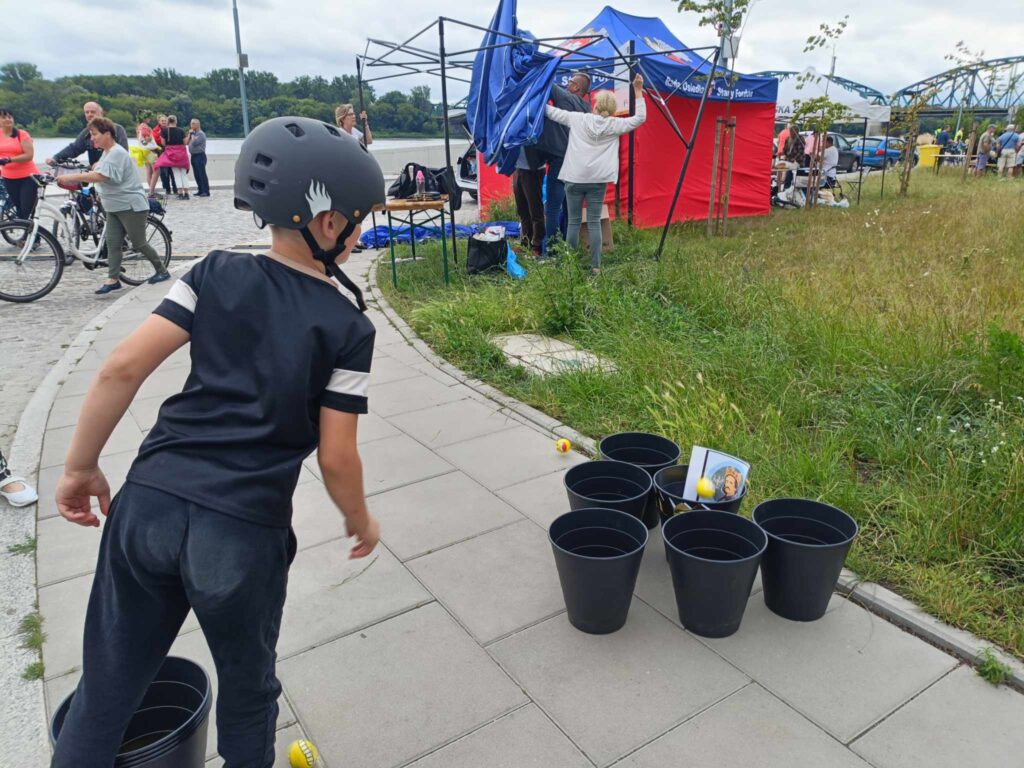 chłopiec rzucający piłką do wiadra z wizerunkiem króla Jagiełły
